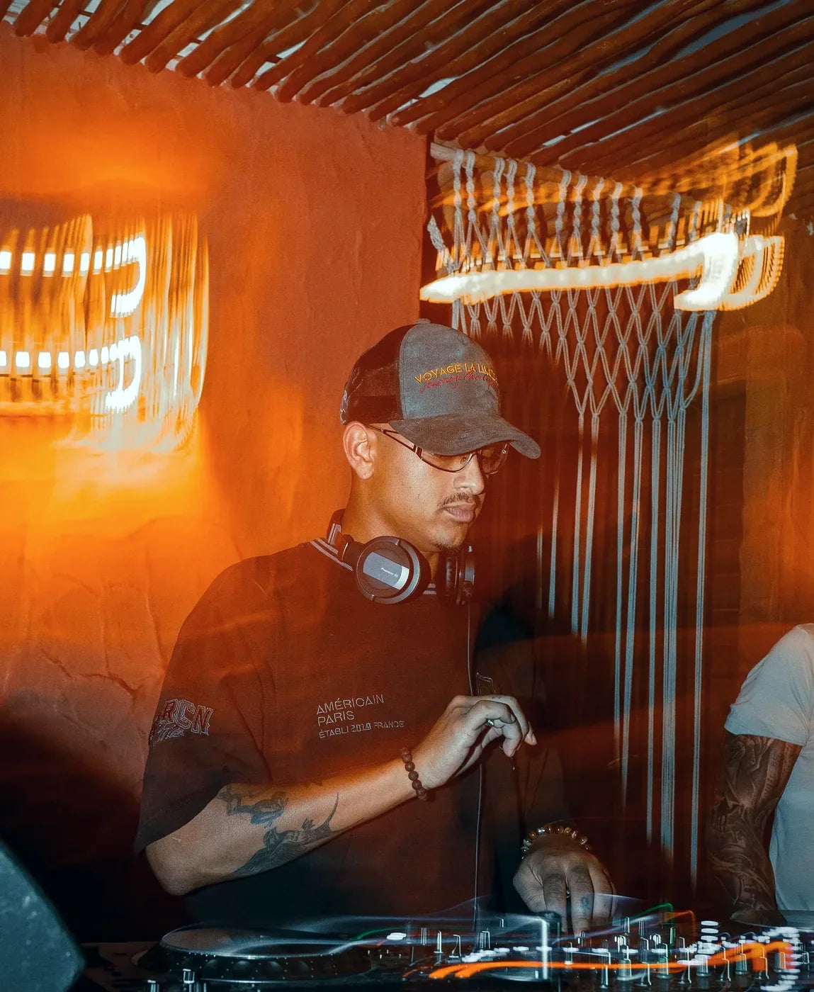 Worn behind the decks under warm light.